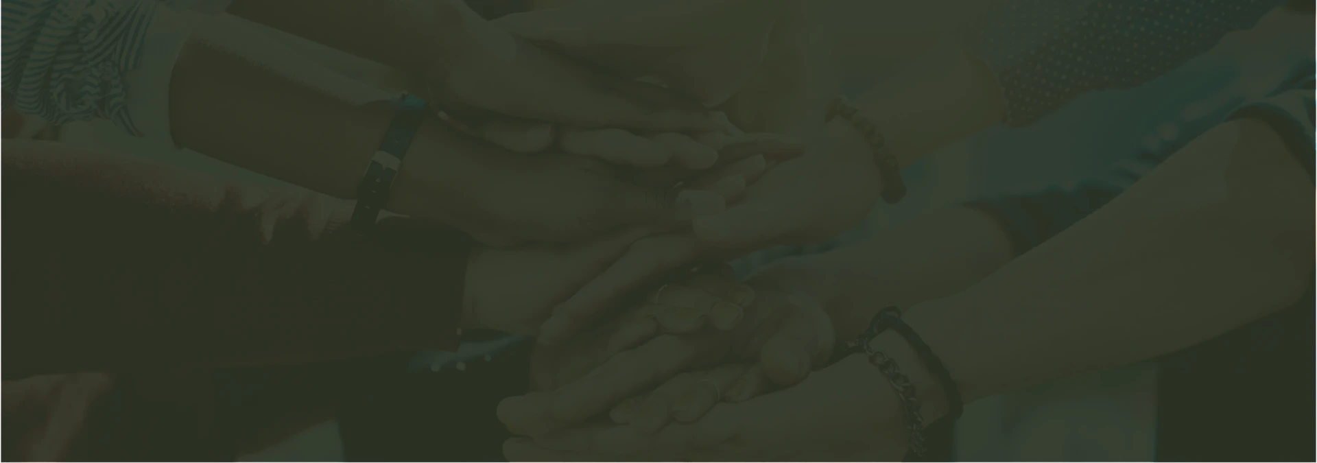 Many hands stacked together in support of a shared mission